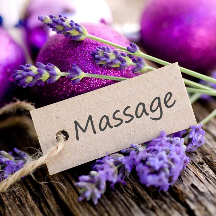 A tag reading "Massage" placed among lavender flowers and purple ornaments.