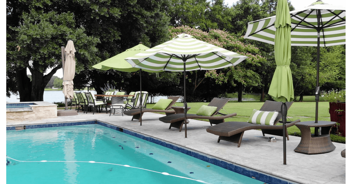 A serene poolside area with lounge chairs and green-striped umbrellas surrounded by lush greenery. A serene poolside area with lounge chairs and green-striped umbrellas surrounded by lush greenery.