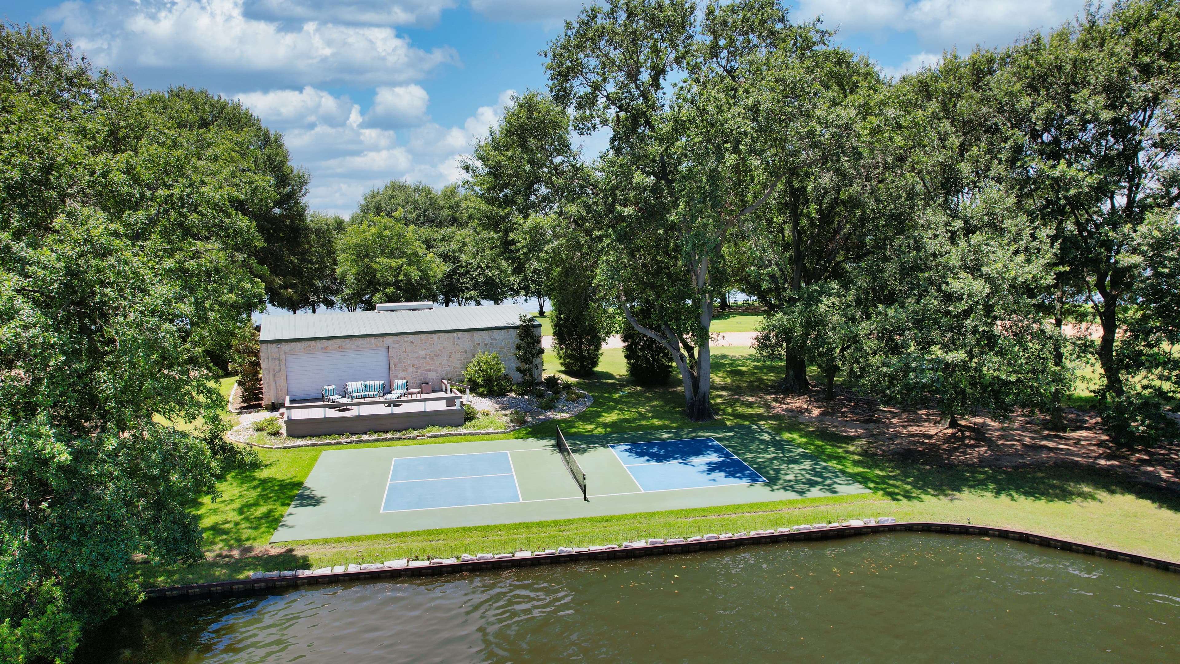 Pickleball court set on a grassy lakefront lawn